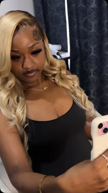 Long blonde curls and styled edges in a client mirror photo.